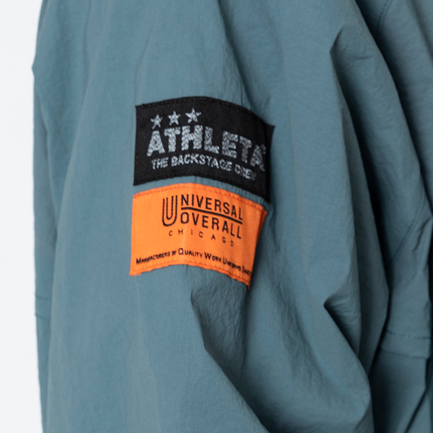 UNIVERSAL OVERALLxATHLETA – TBCウインドZIPパーカー